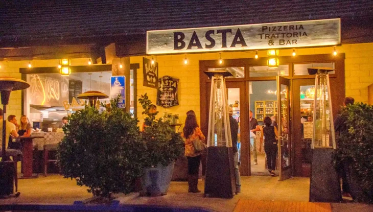 basta-restaurant-agoura-hills-entrance-night Front entrance of BASTA Restaurant in Agoura Hills at night, with guests entering and warm ambient lighting highlighting the Pizzeria Trattoria & Bar sign