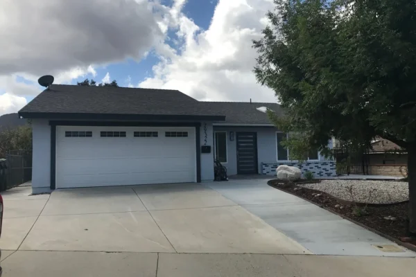Exterior view of Ladyface View Living assisted living home in Agoura Hills, California, showing front yard and driveway under partly cloudy sky