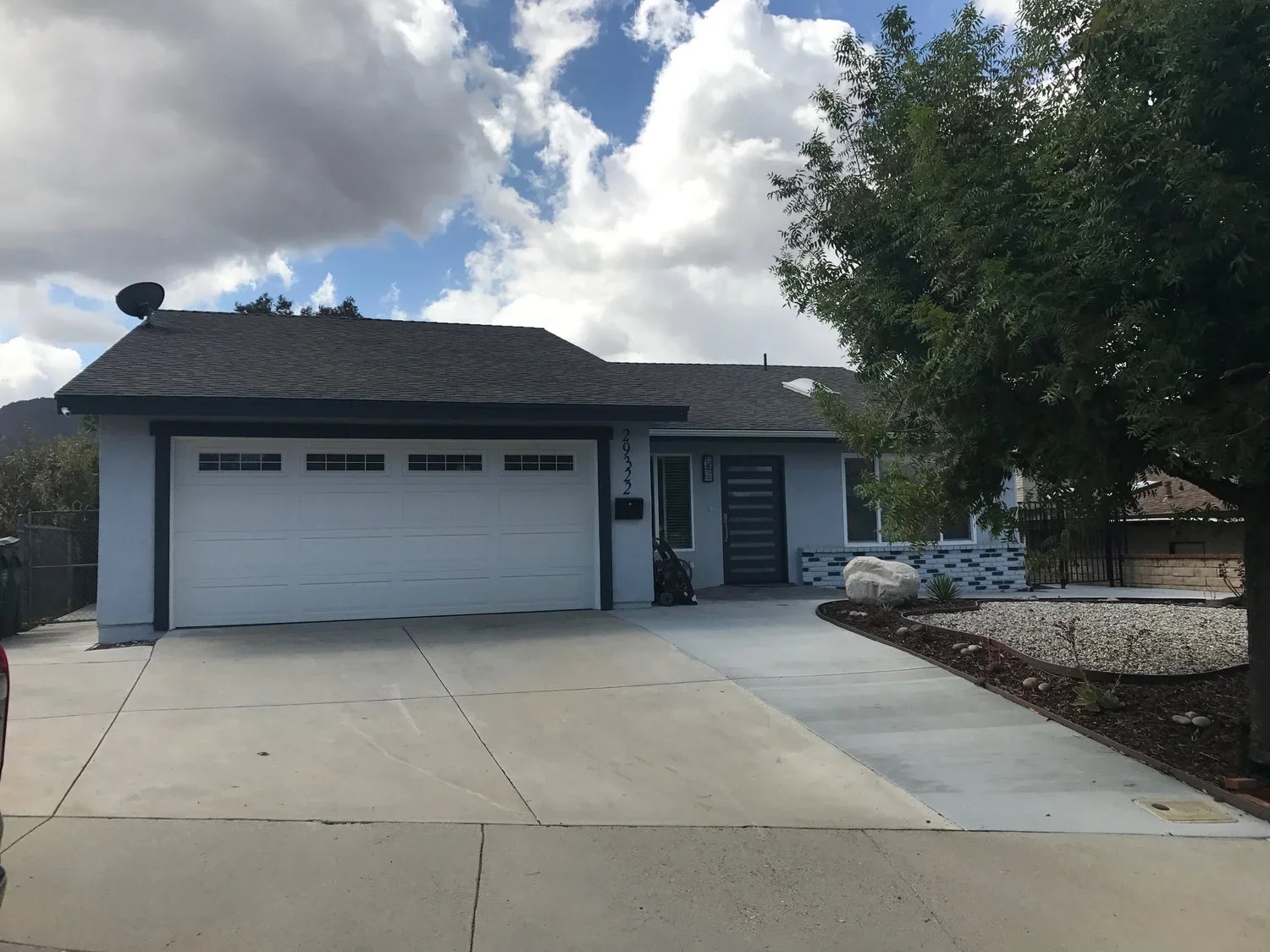 Exterior view of Ladyface View Living assisted living home in Agoura Hills, California, showing front yard and driveway under partly cloudy sky