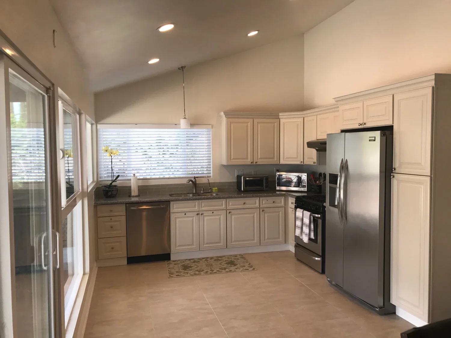 Bright kitchen at Ladyface View Living LLC featuring stainless-steel appliances, light cabinetry, and wide windows overlooking the patio