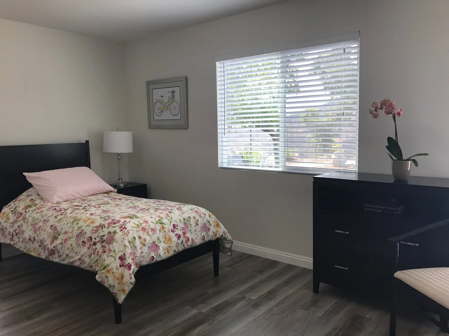 Private bedroom at Ladyface View Living LLC with floral bedding, large window, and minimalist furniture creating a bright, peaceful atmosphere