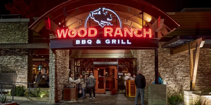 wood-ranch-agoura-hills-entrance Front entrance of Wood Ranch BBQ & Grill in Agoura Hills with illuminated red signage and guests arriving at night