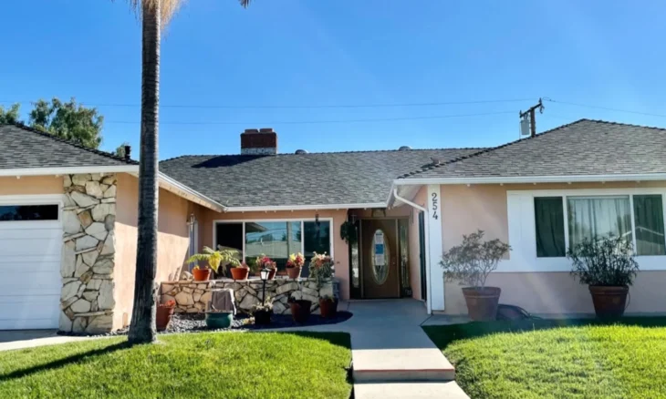 front_view_254_east_sidlee_home Front view of 254 East Sidlee care home with palm tree and green lawn.