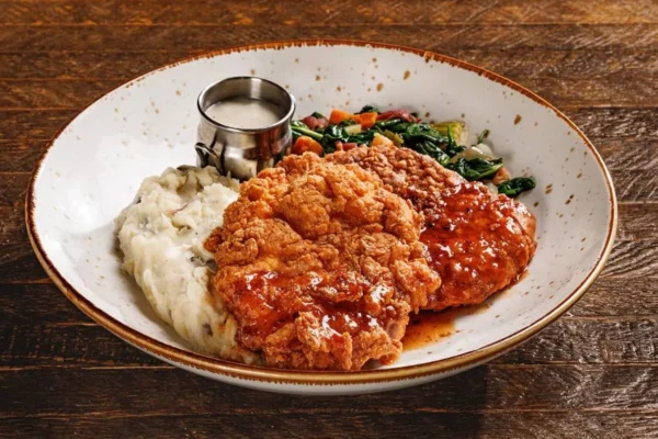 Crispy chicken fried steak with mashed potatoes and vegetables