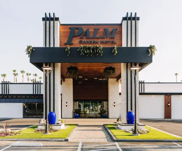 Front entrance of Palm Garden Hotel in Thousand Oaks with modern facade, tall columns and landscaped driveway