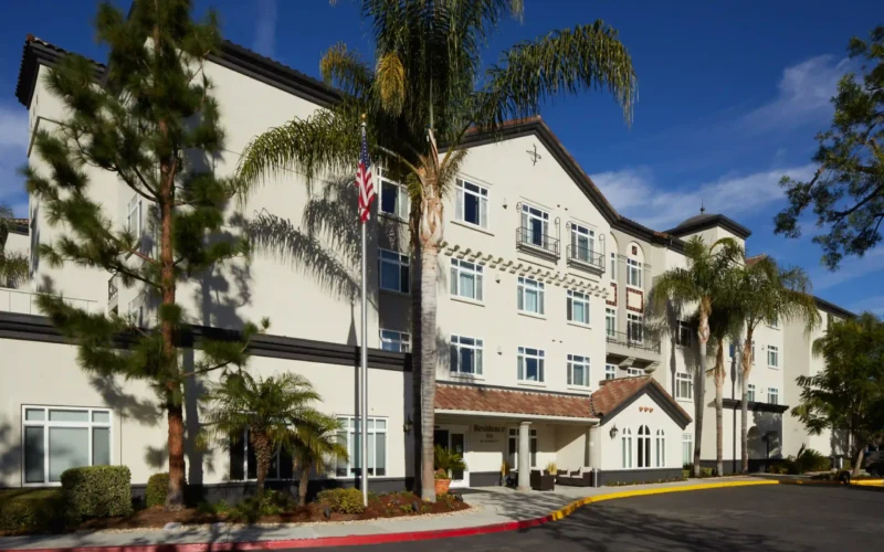 Exterior view of Residence Inn Los Angeles Westlake Village surrounded by palm trees and a clear blue sky.