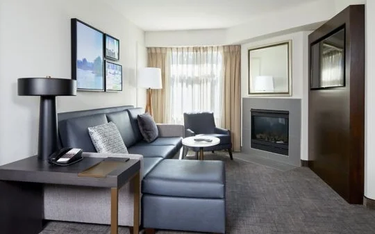 Modern living room at Residence Inn Westlake Village with a sofa, fireplace, and bright window light.