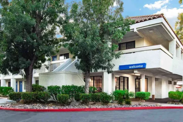 Motel 6 Thousand Oaks exterior with covered entrance, “welcome” sign, and landscaped driveway.